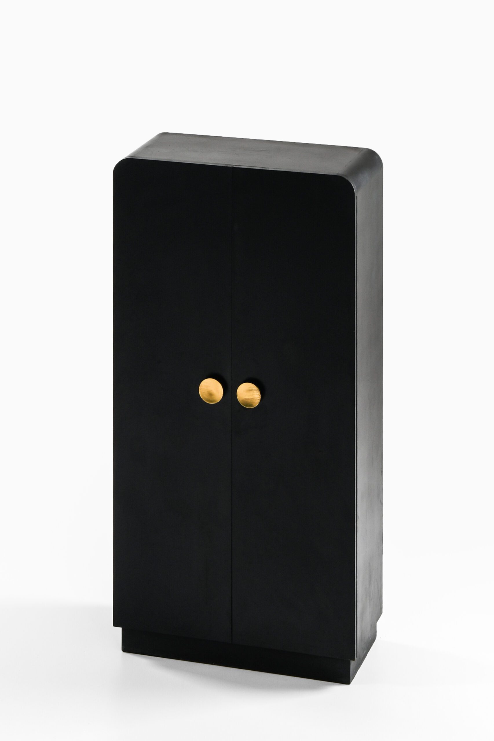 Black lacquered wood cabinet with brass pulls at Studio Schalling